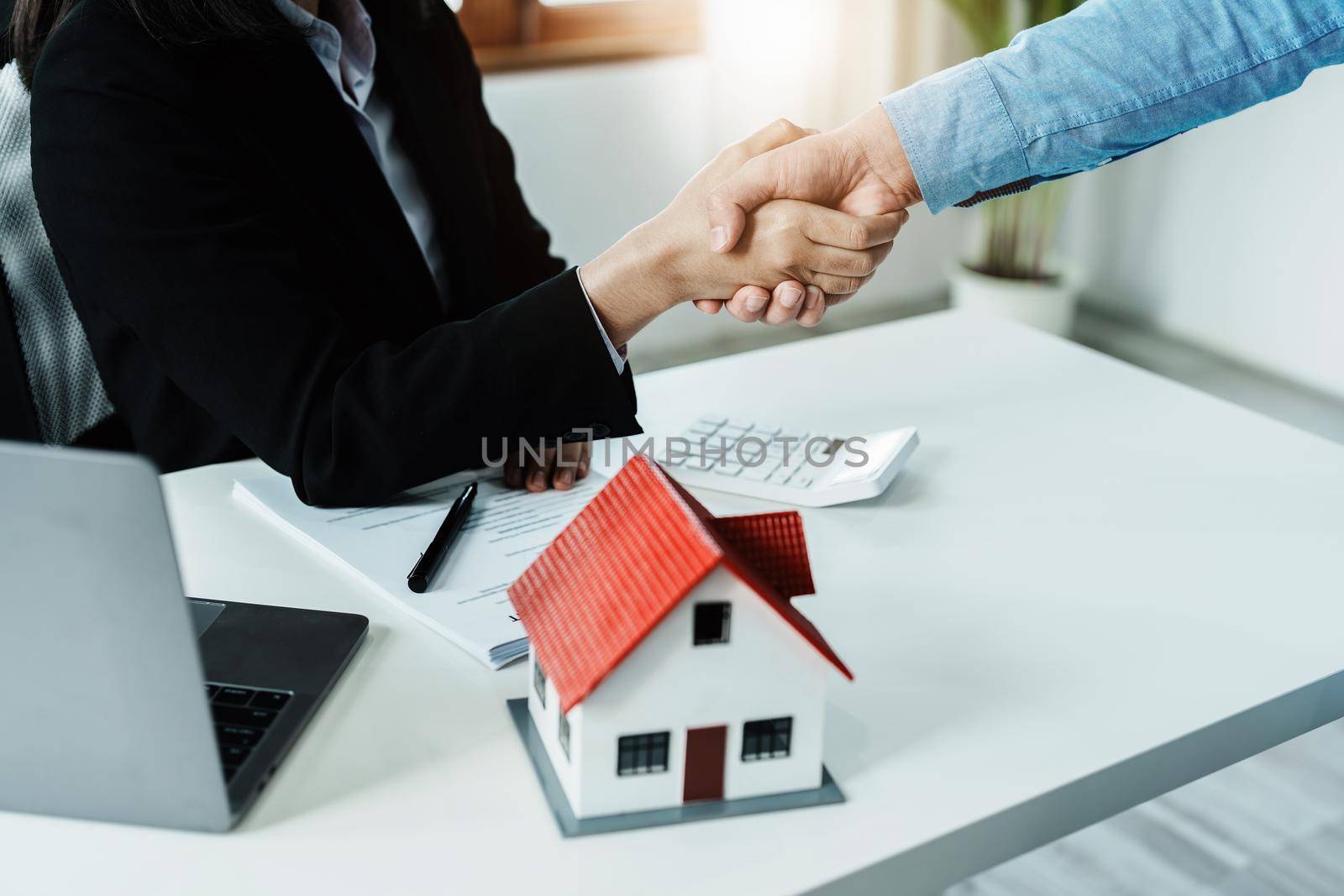 Laws, contracts, mortgages, clients join hands with real estate agents congratulating real estate agents on home and land purchase agreements with insurance to reduce risks during home installments by Manastrong