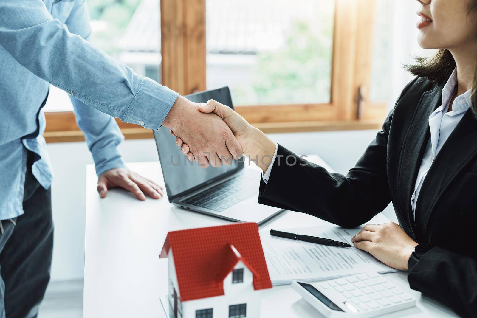 Laws, contracts, mortgages, clients join hands with real estate agents congratulating real estate agents on home and land purchase agreements with insurance to reduce risks during home installments by Manastrong