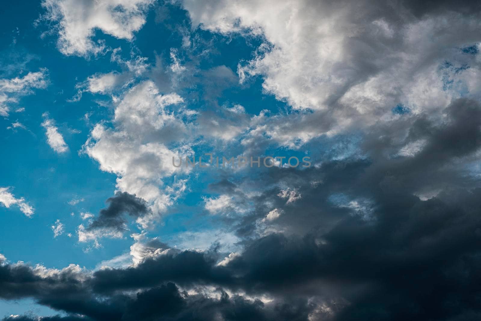 Gray clouds in the blue sky background and the sun