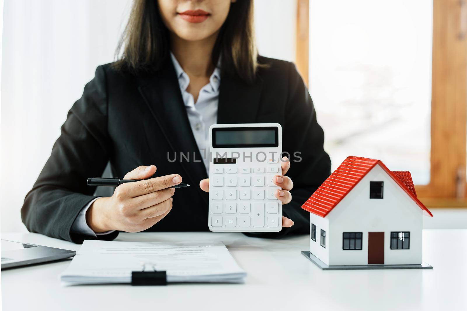 Entrepreneurs, business owners, accountants, real estate agents, A young woman uses a calculator to calculate her home budget to assess the risks of investing in real estate. by Manastrong