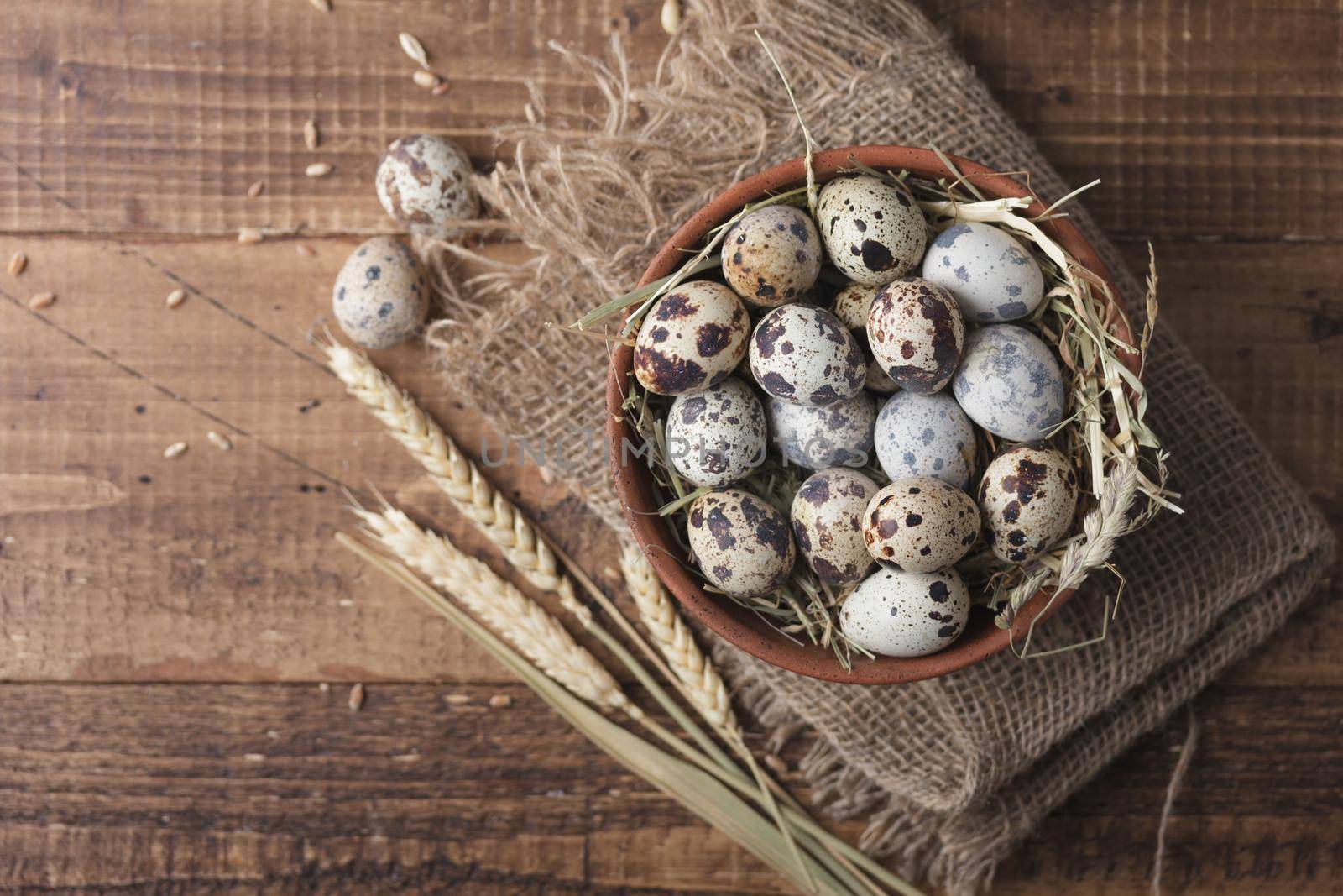 Quail eggs in a bowl top view on a wooden table