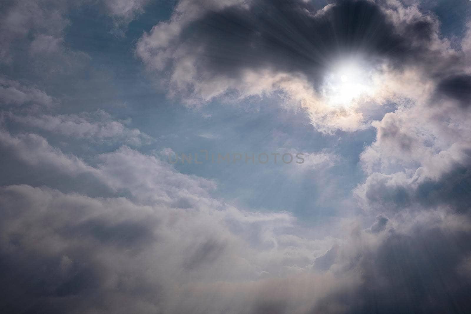 Gray clouds in the blue sky background and the sun