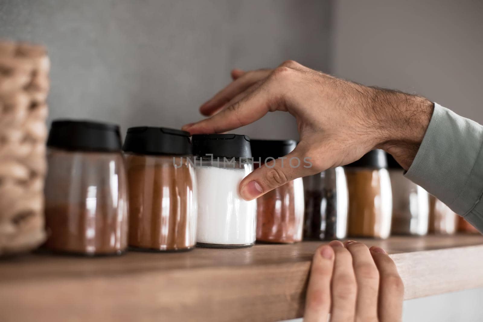 close up. a man takes spices from the kitchen shelf. photo with copy space