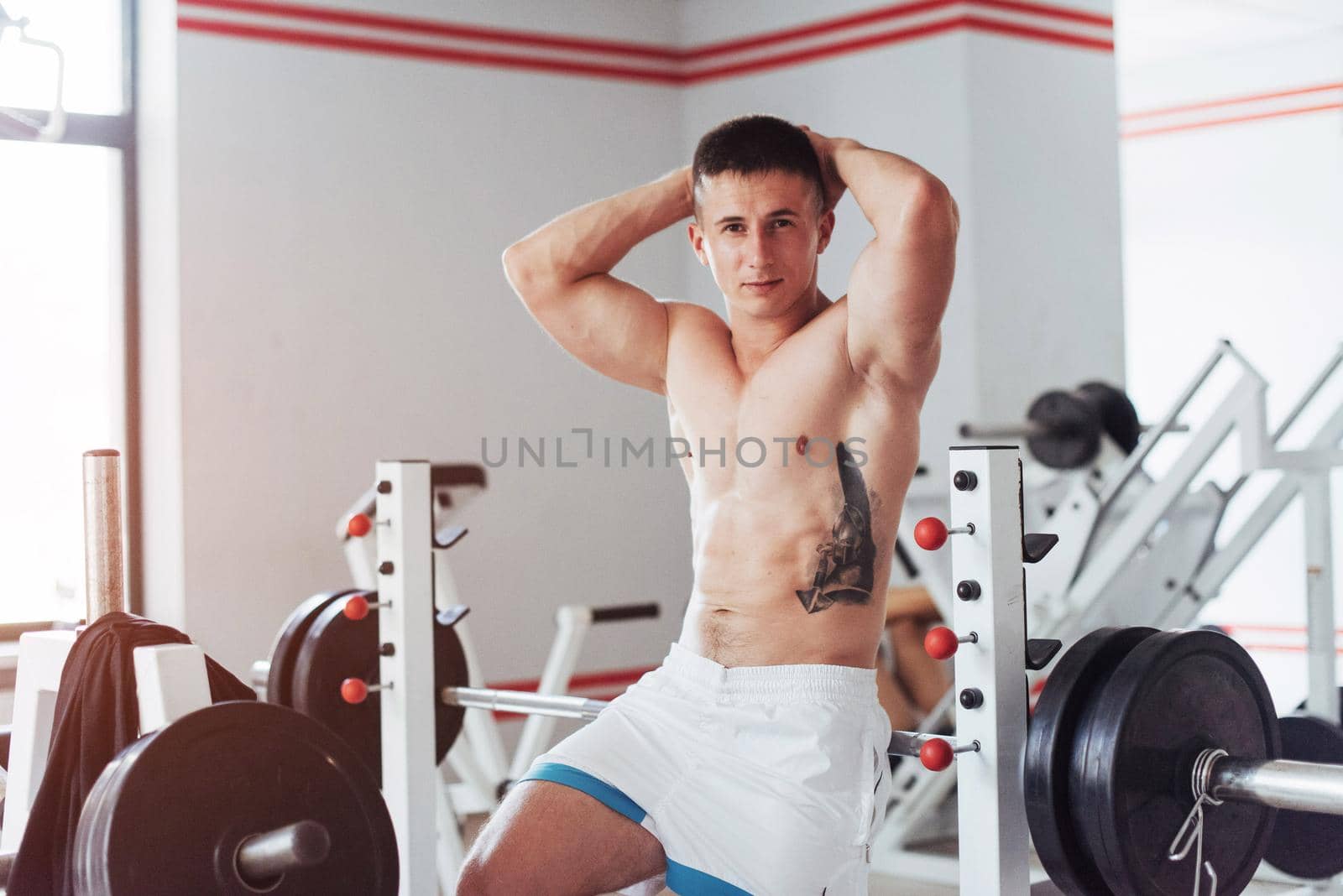 Portrait of a beautiful and attractive young man with muscular body relaxing in the gym, showing strong chest