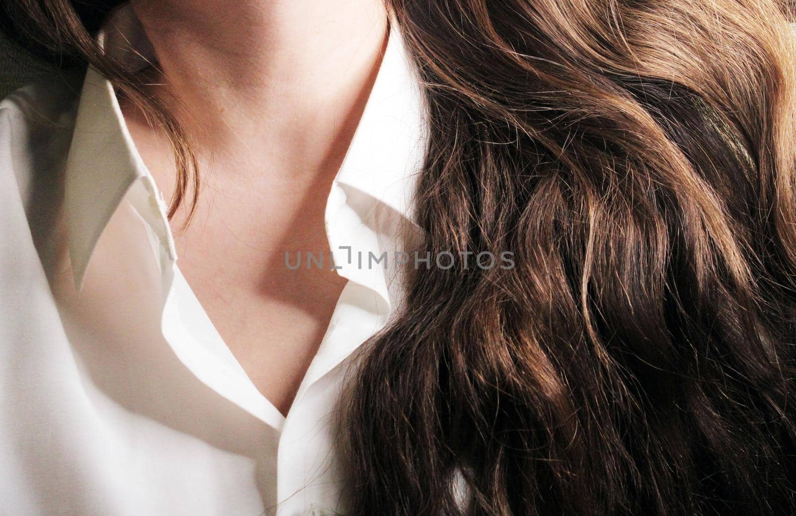 A beautiful girl in a white shirt with loose long dark hair..