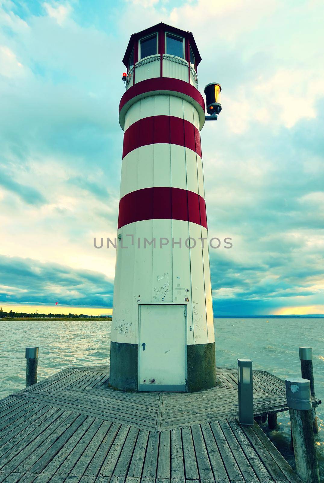 Romantic evening walk on wooden mole to Lighthouse at Lake Neusiedl (Podersdorf am See) at sunset, Burgenland, Austria