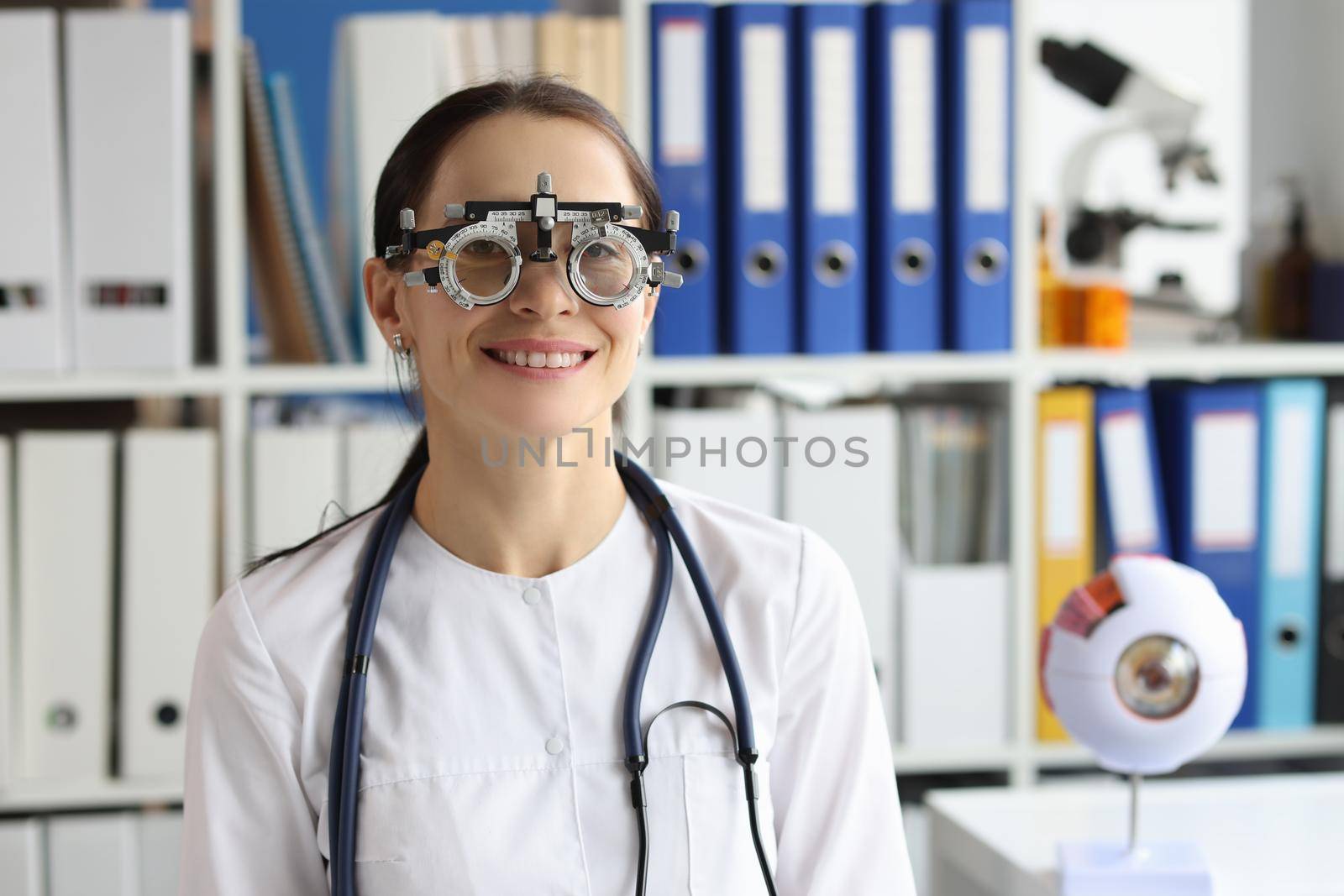 Portrait of ophthalmologist wear optometrist trial frame at ophthalmology office, select glasses for better vision. Eye check-up, medicine, oculist concept