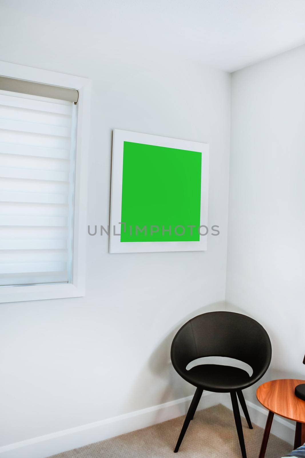 A reading chair armchair with a lamp, blanket and a open book. Empty white wall in simple living room interior. Copy space