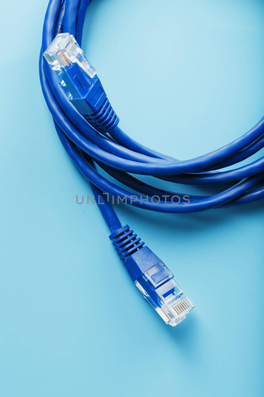 Two Ethernet Cable Connectors Patch cord cord close-up isolated on a blue background with free space by AlexGrec