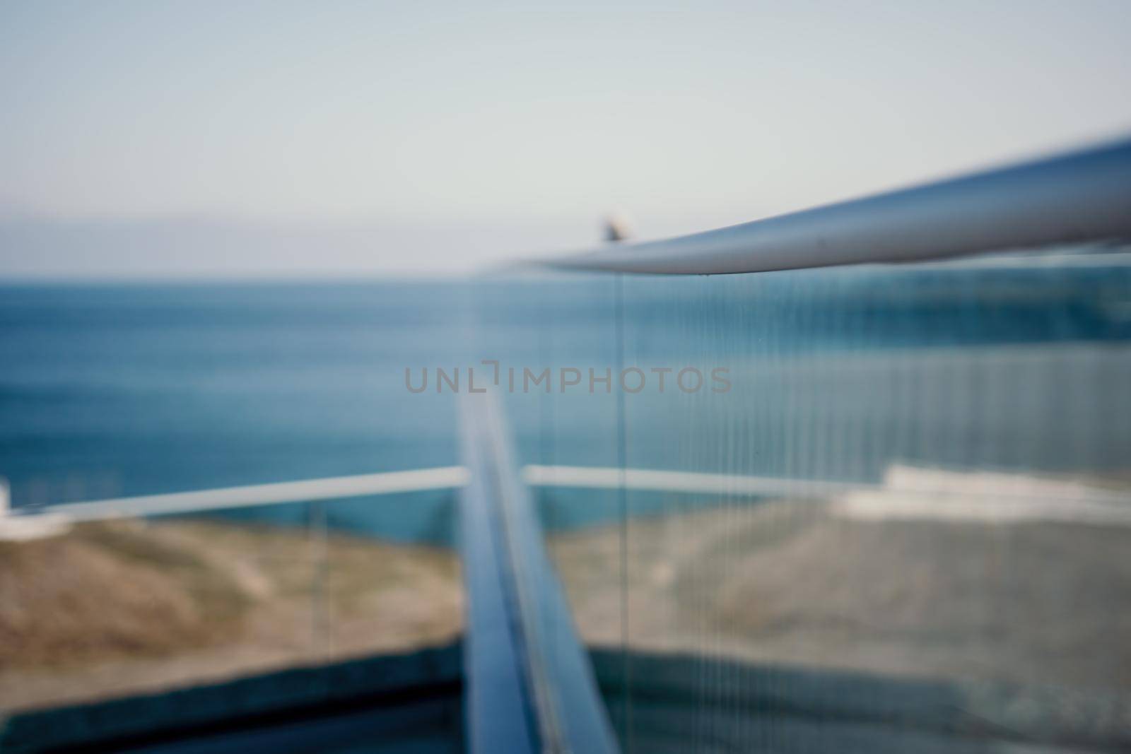 Abstract selective focus glass fence in the seaside park. a popular viewpoint, admiring the natural beauty of the sunset. An observation deck with a figured fence and a lantern. City view. by panophotograph