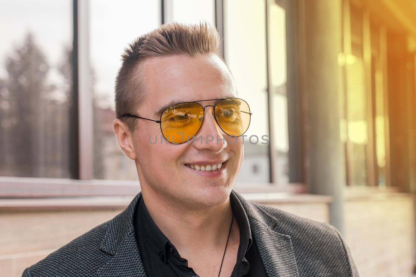 Portrait of a positive smiling attractive businessman of Caucasian appearance in sunglasses.