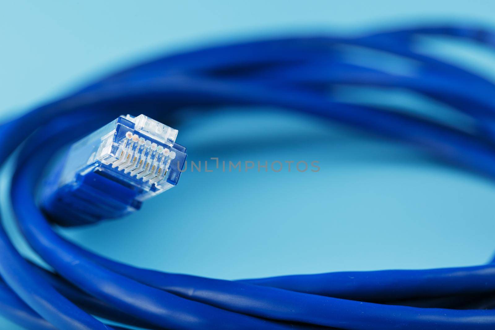 Blue Ethernet Cable Cord Patch cord on a blue background with free space by AlexGrec