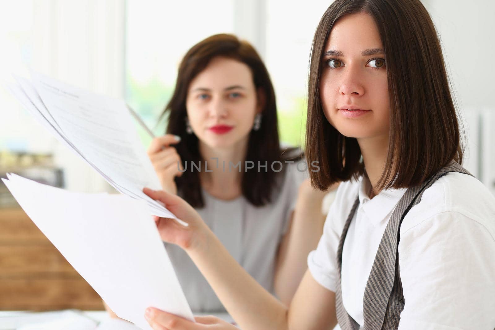 Portrait of businesswomen in office with bunch of financial papers, loaded with work. Success, career, teamwork, business, office life, deadline concept