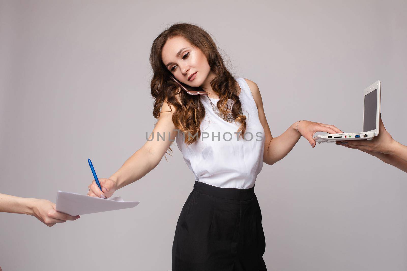 Woman talking by phone, using computer and signing papers by StudioLucky