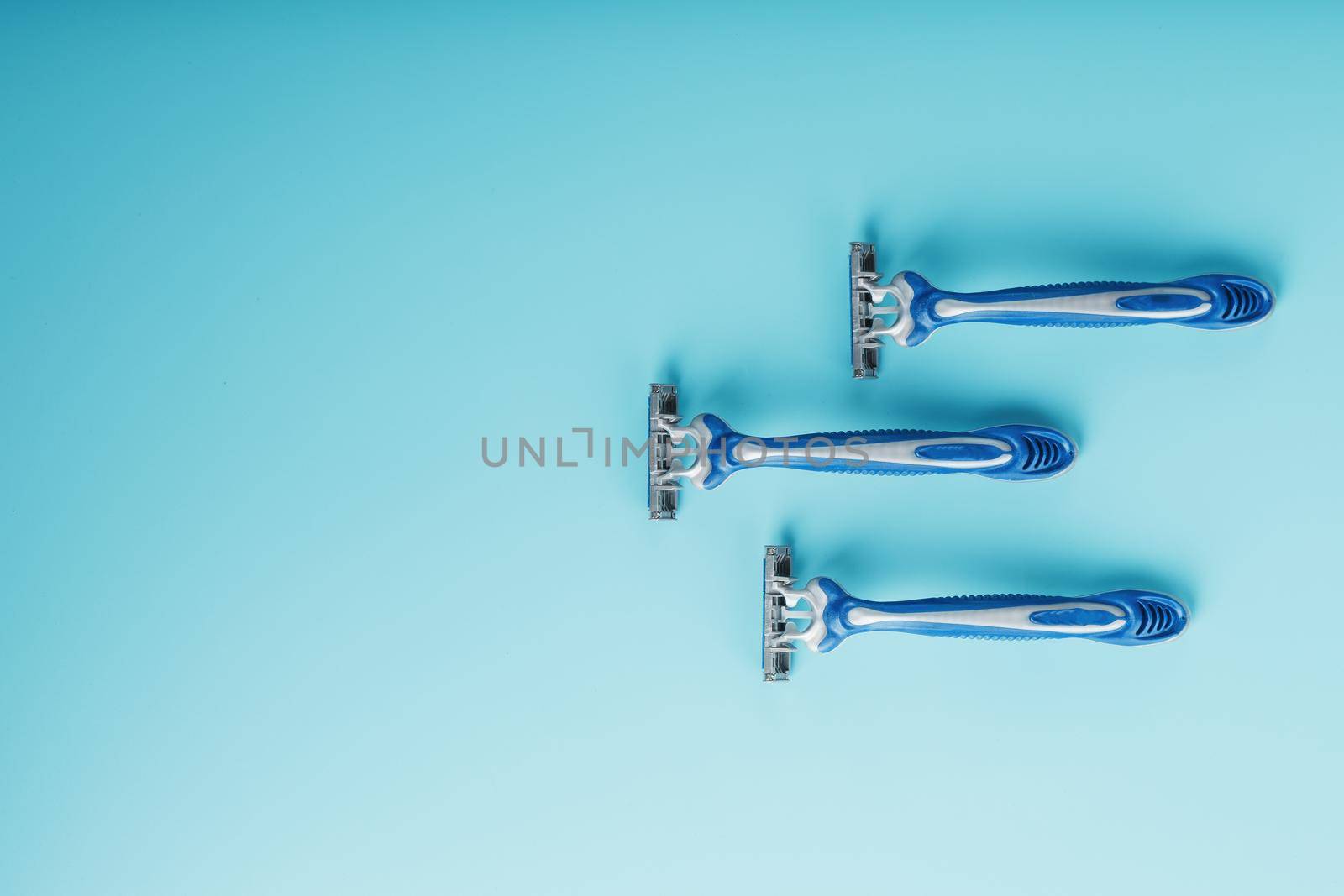 Blue shaving machines in a row on a blue background with ice cubes by AlexGrec