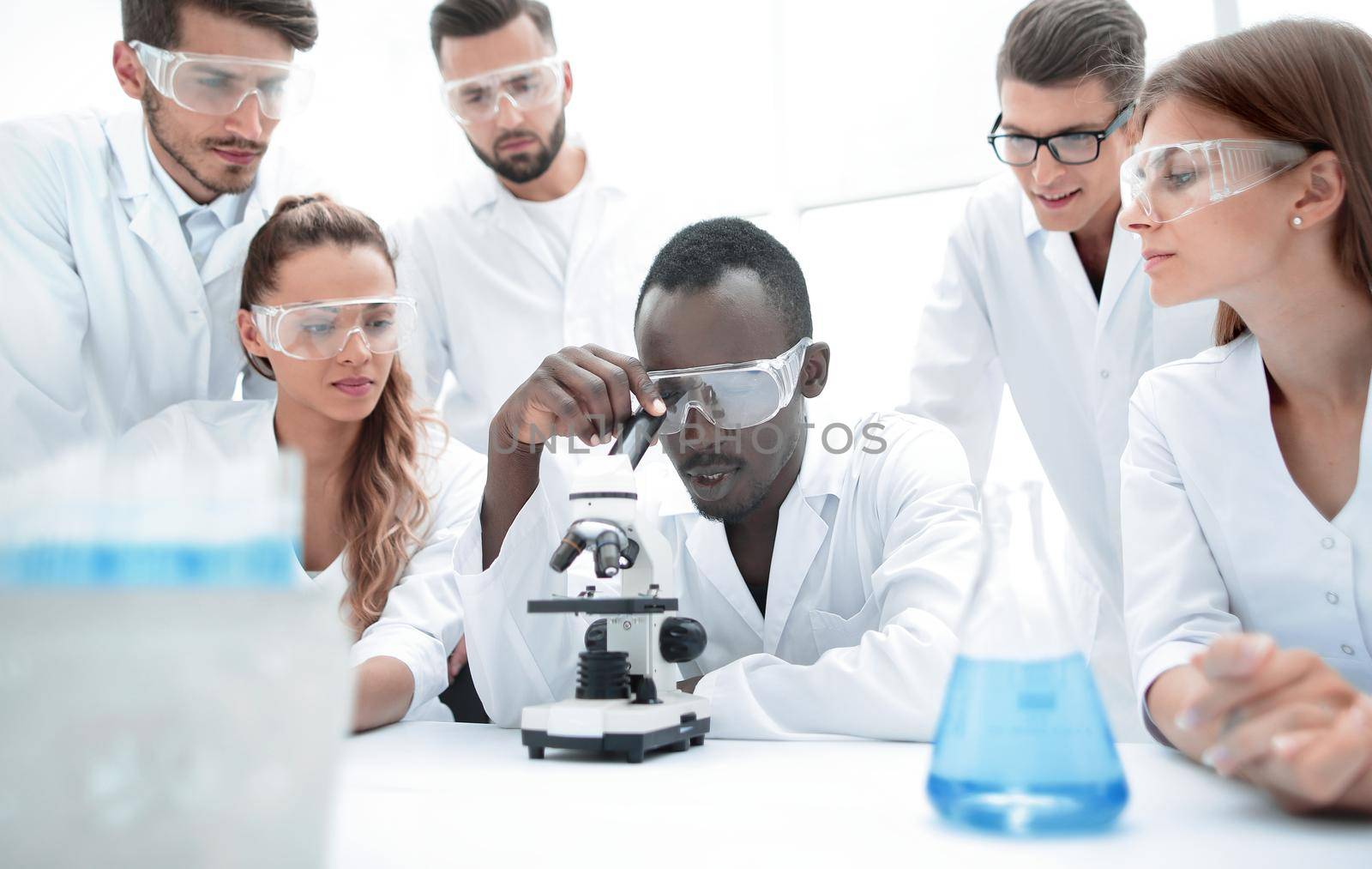 Group of young scientists working in the chemical laboratory by asdf
