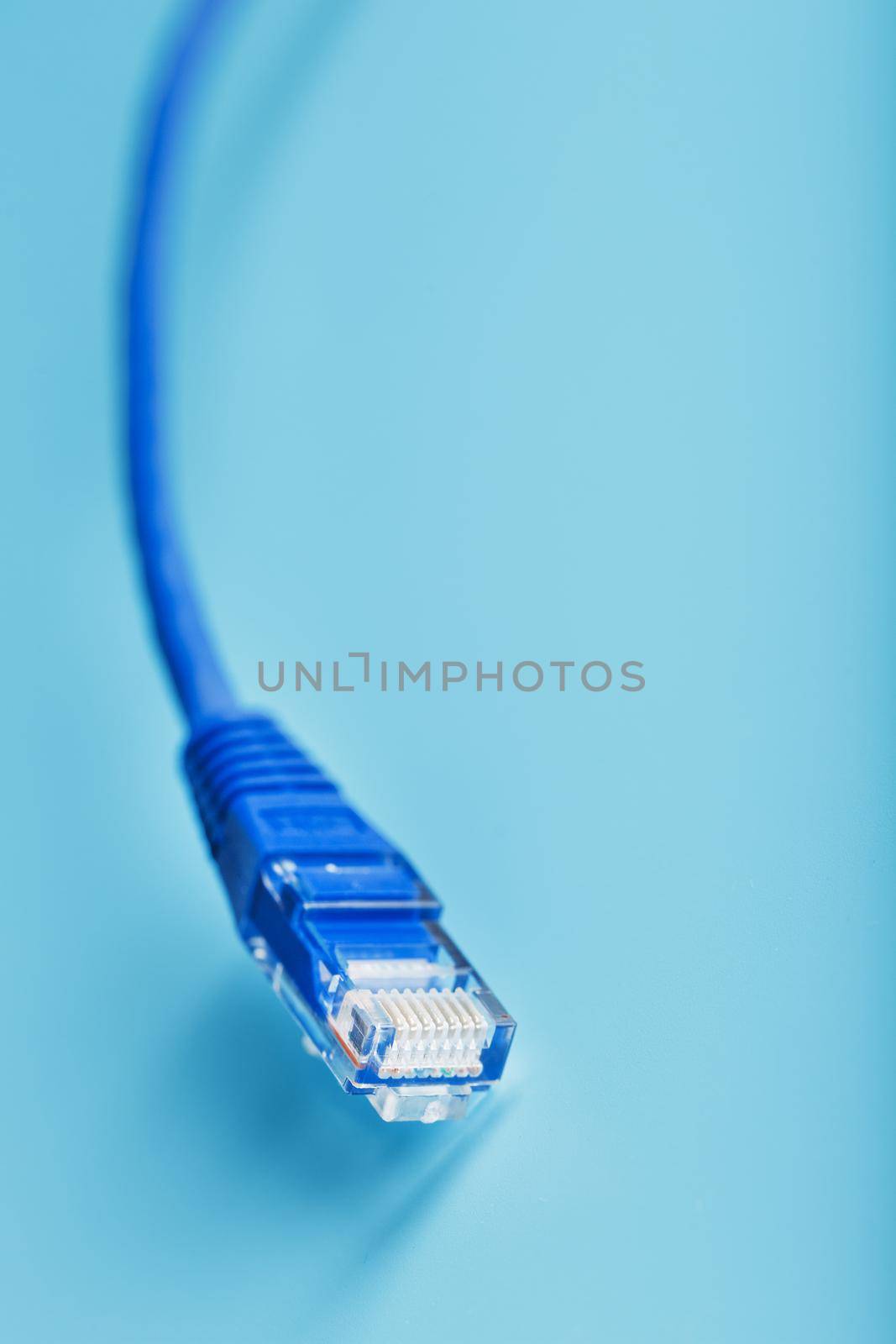 Blue Ethernet Cable Cord Patch cord on a blue background with free space by AlexGrec