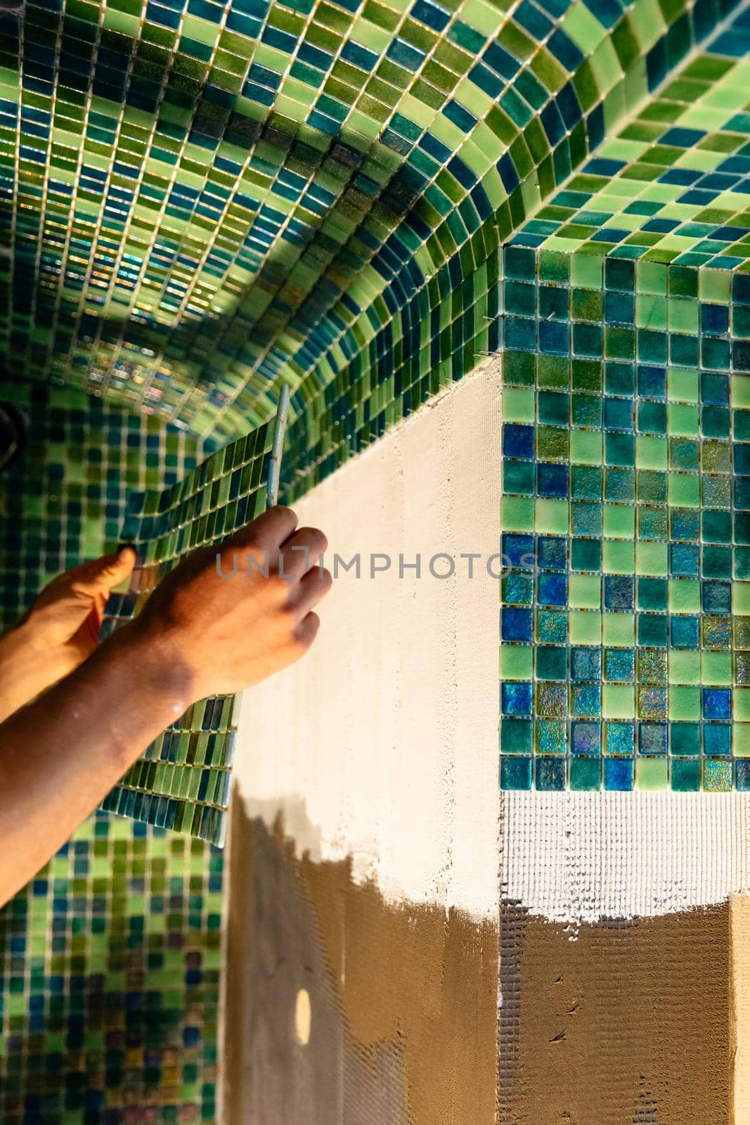 Applying modern mosaic tiles. Spa or sauna relaxation modern room interior design. Bathroom renovation.