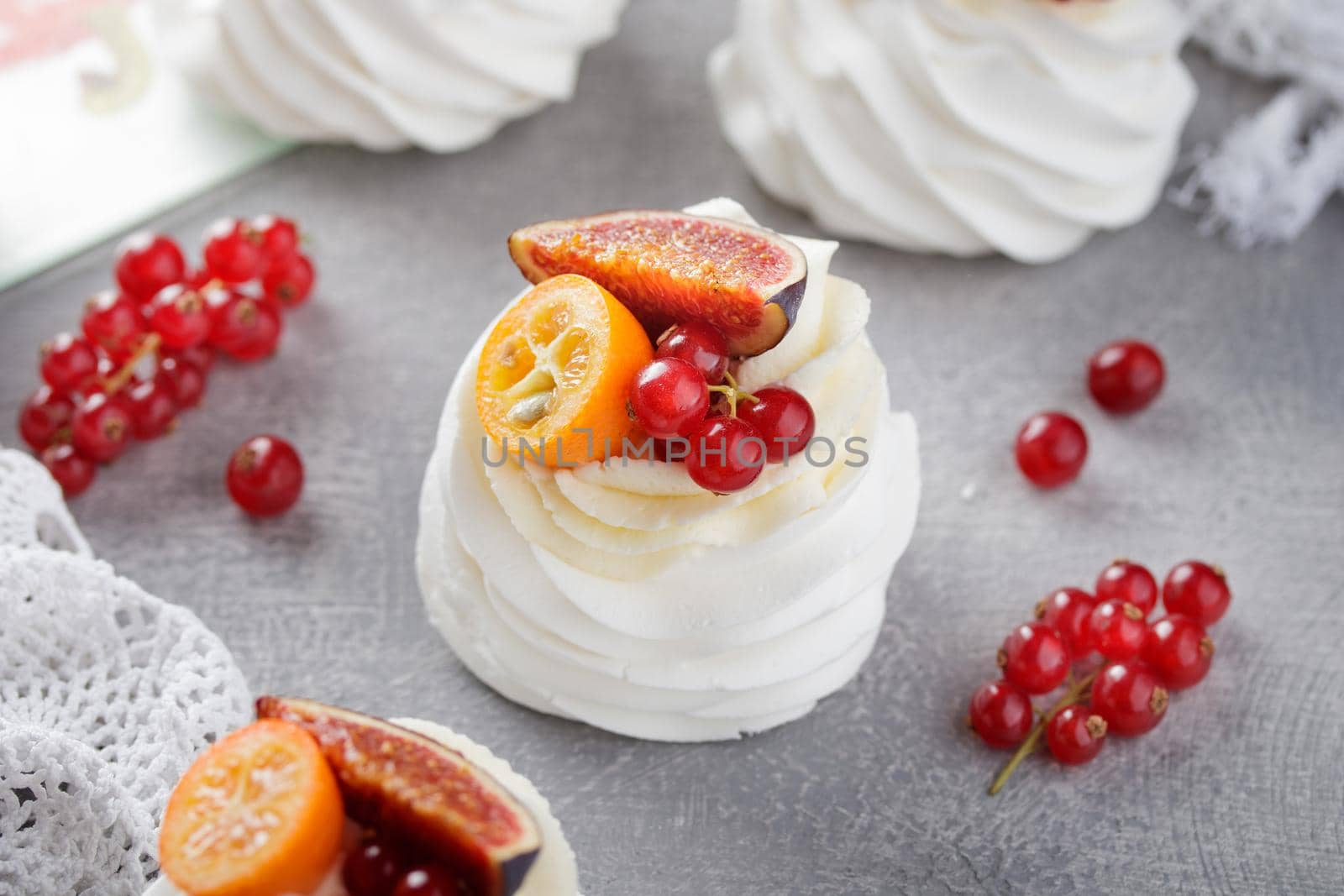 Pavlova dessert with berries on a gray background