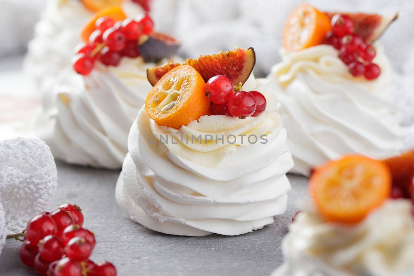 Pavlova dessert with berries on a gray background