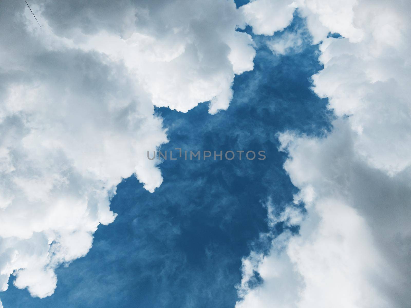 Cumulus clouds diagonally against a dark blue sky with free space