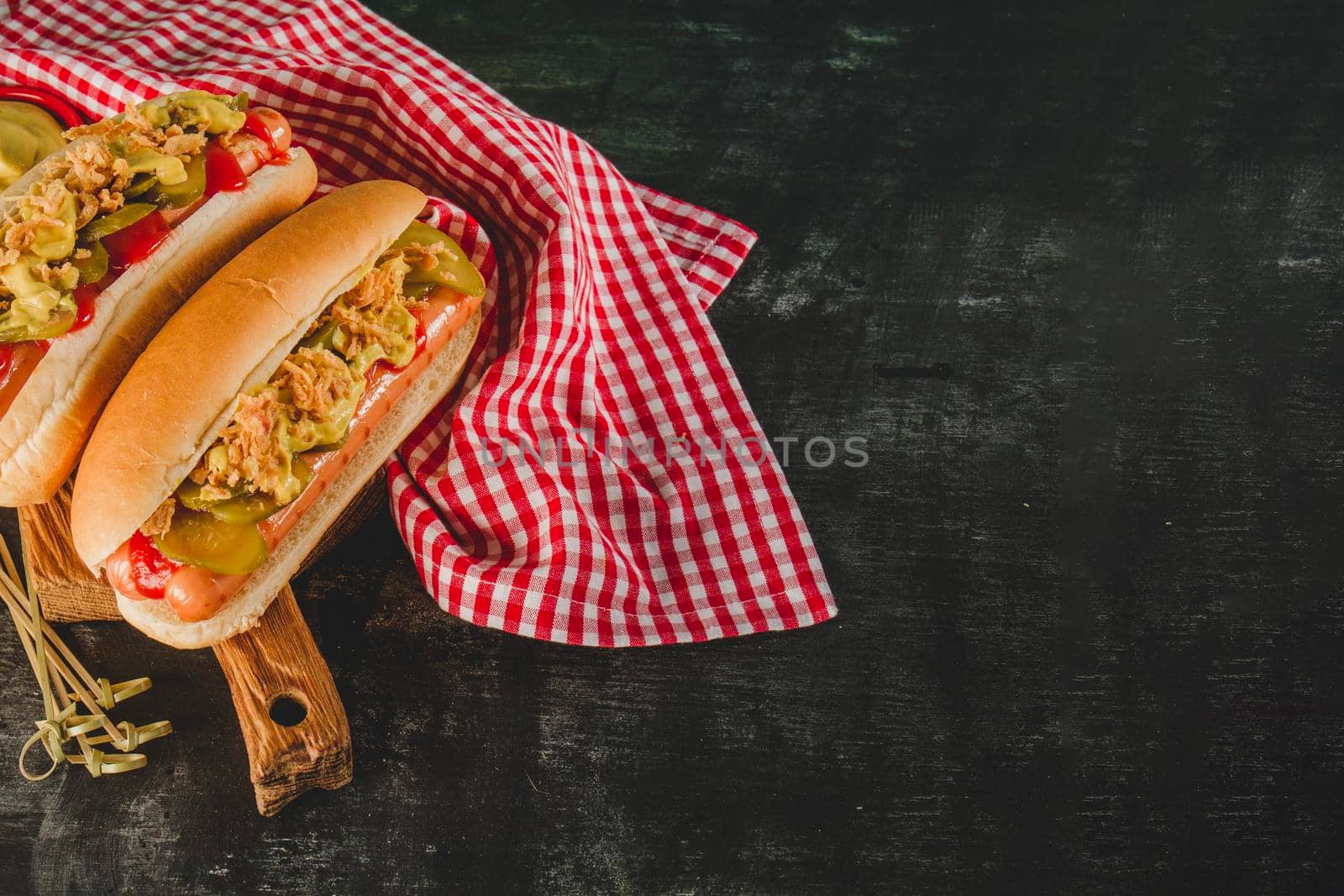 dark surface with tablecloth two delicious hot dogs