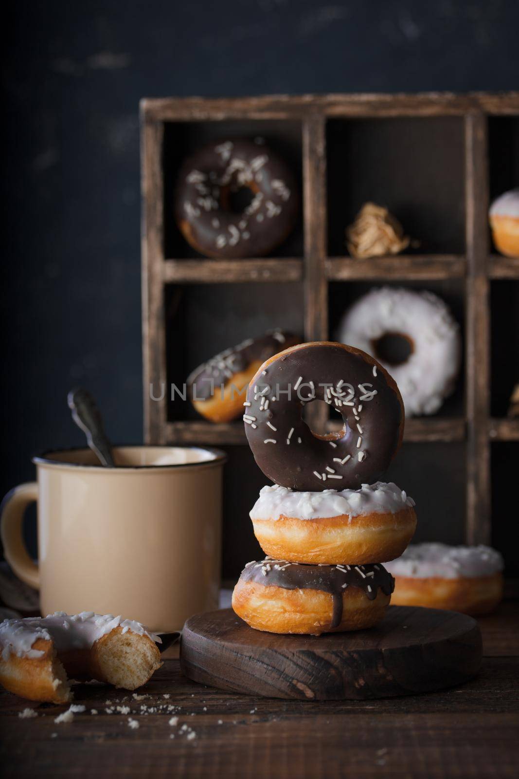 Donuts with dark and white chocolate on a dark background