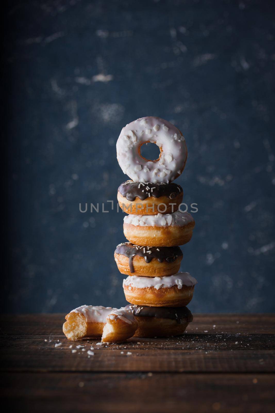 Donuts with dark and white chocolate on a dark background