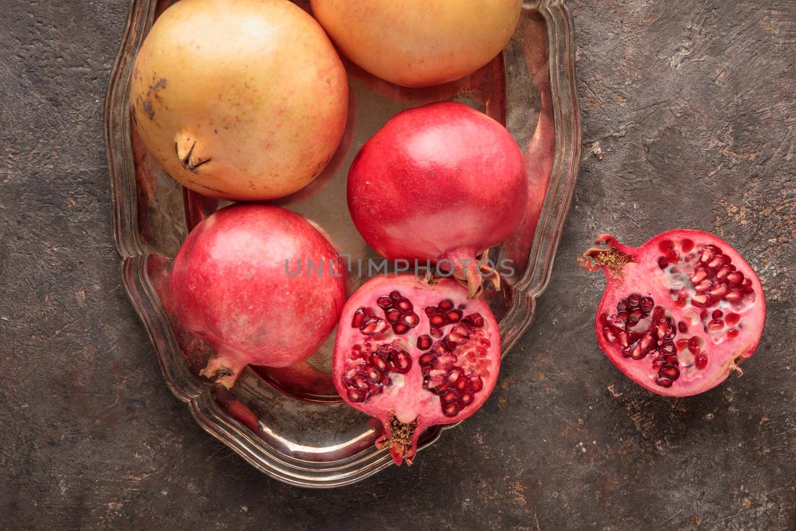 Ripe pomegranates on a dark table background