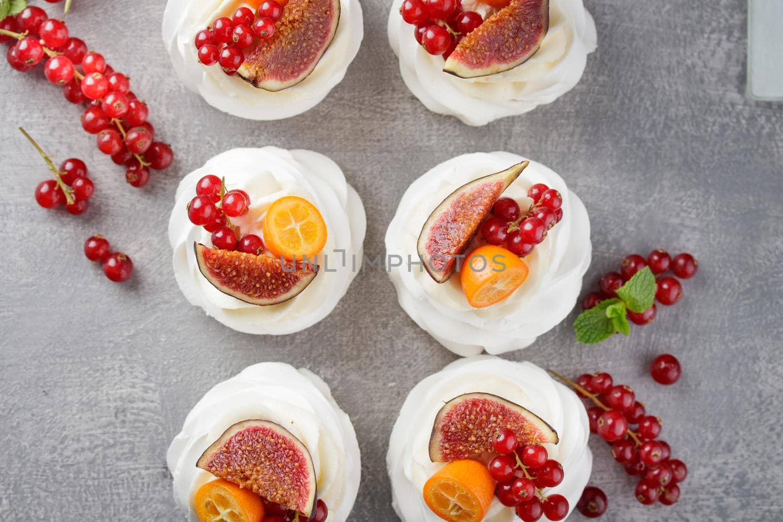 Pavlova dessert with berries on a gray background