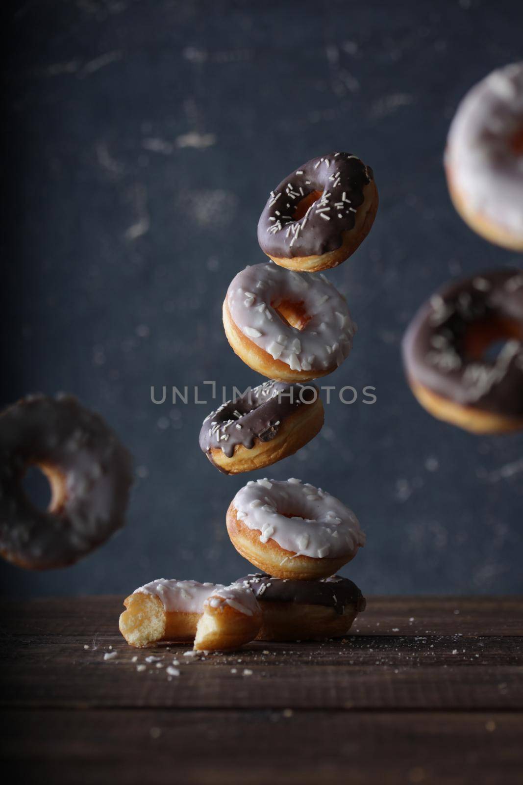 Donuts with dark and white chocolate on a dark background