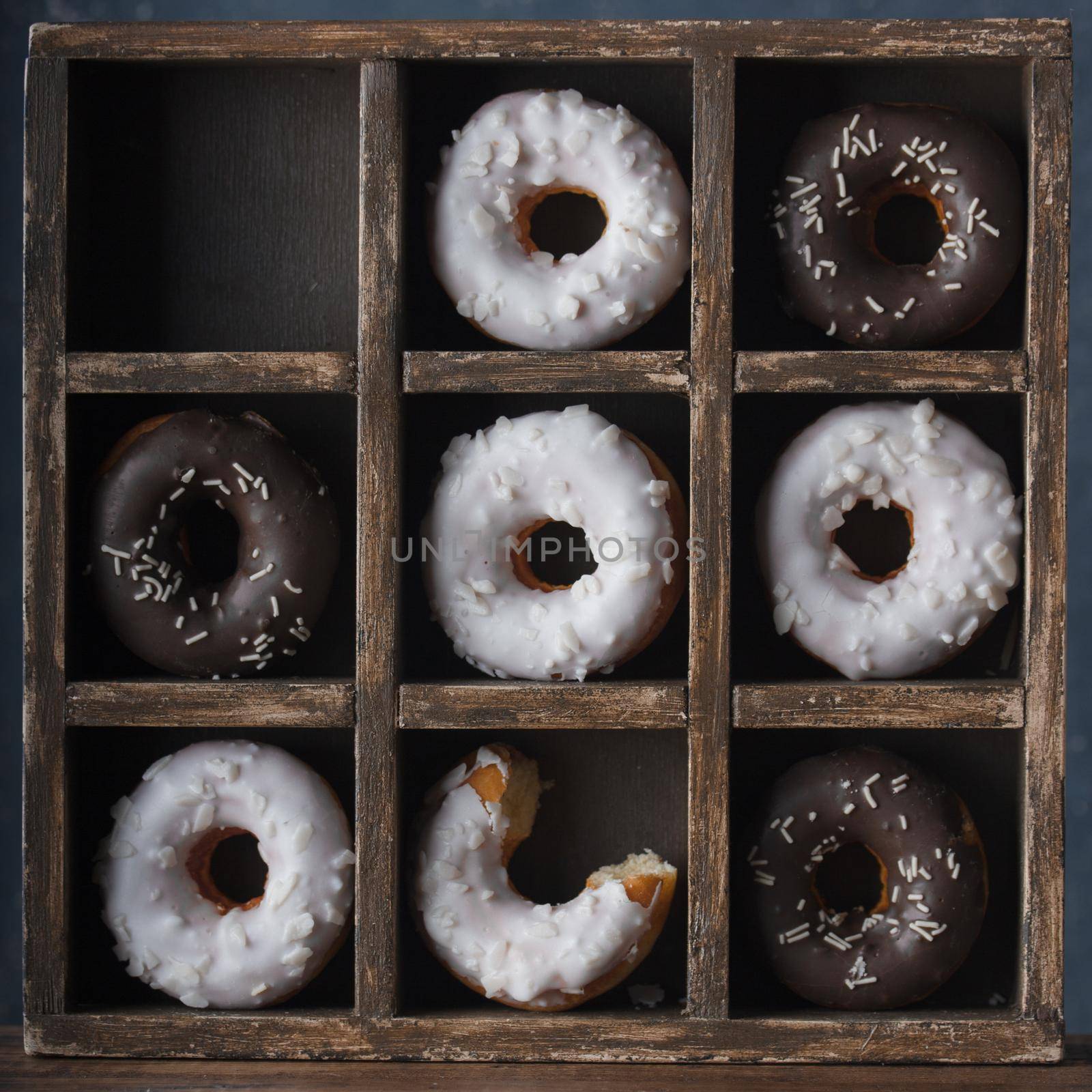 Donuts with dark and white chocolate on a dark background