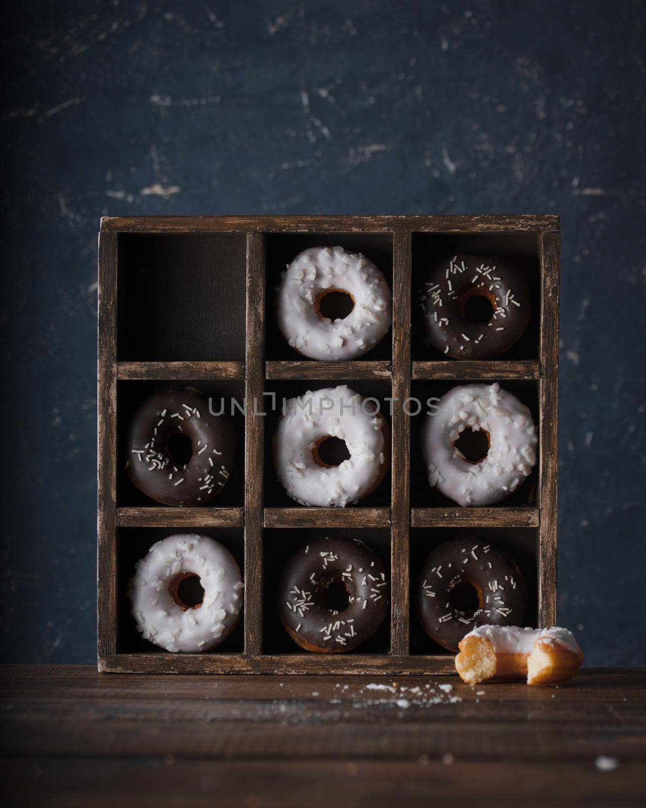 Donuts with dark and white chocolate on a dark background