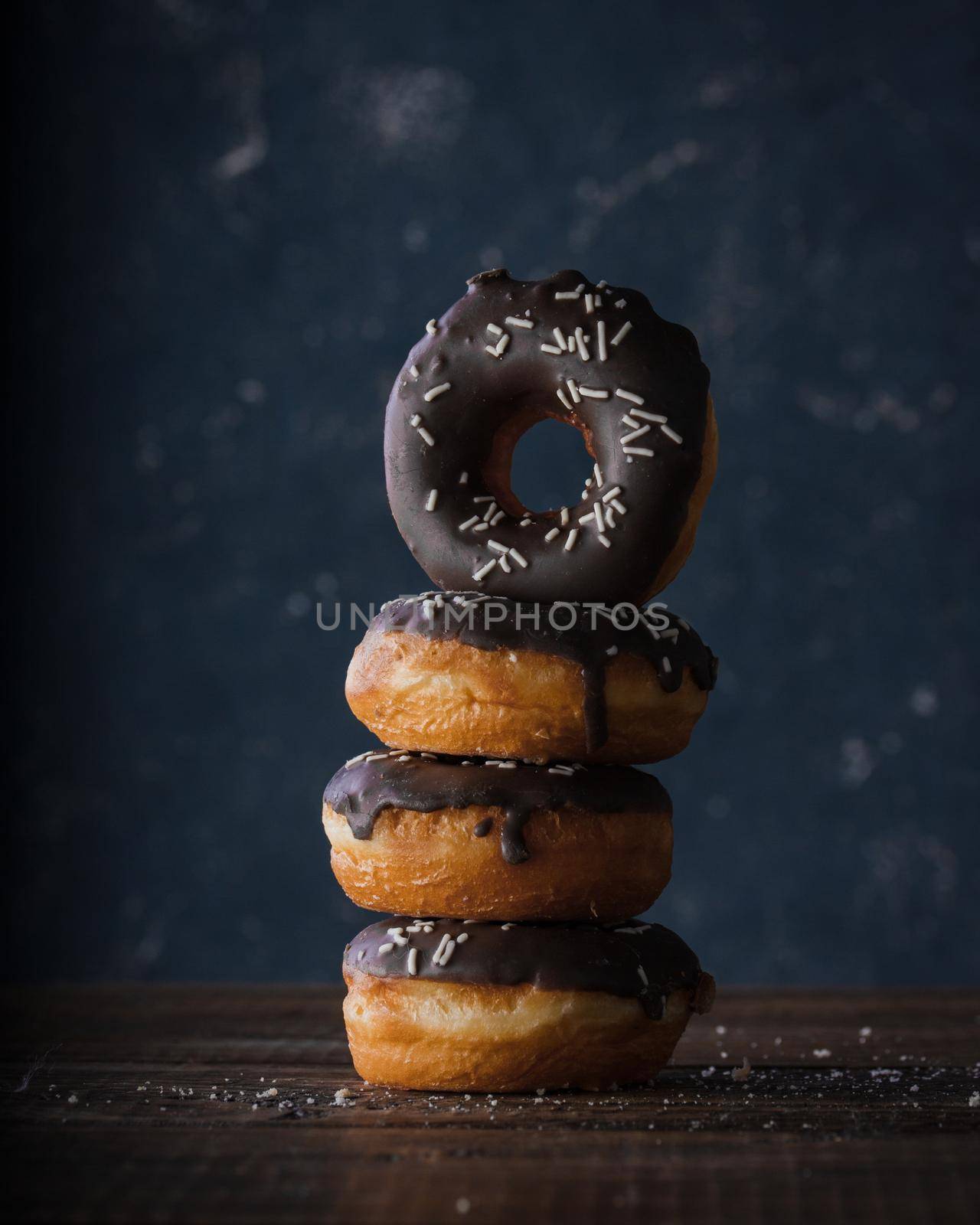 Donuts with dark and white chocolate on a dark background