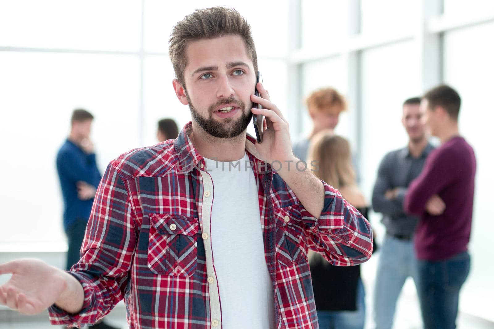 close up. smiling young designer reading a message on his smartphone