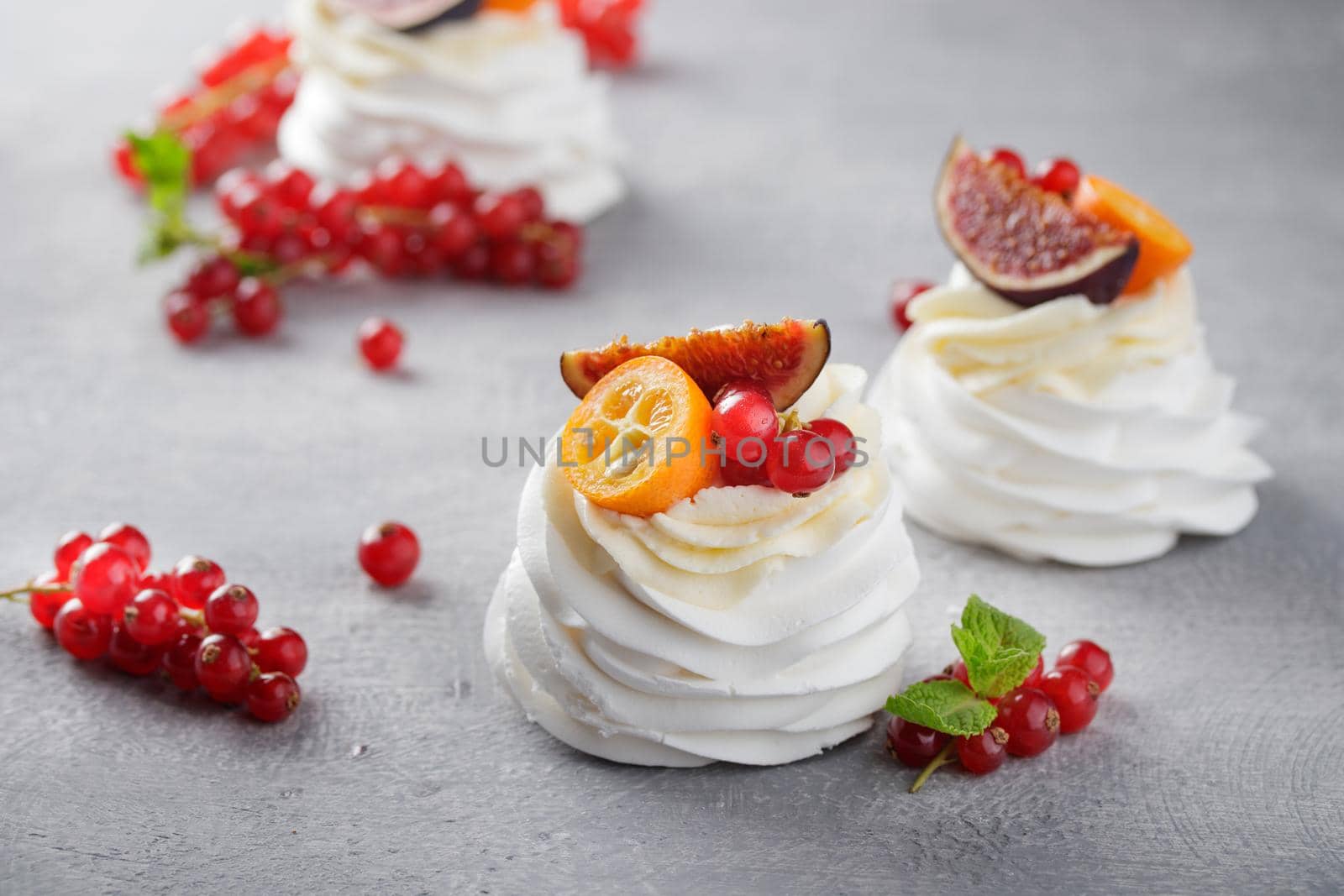 Pavlova dessert with berries on a gray background