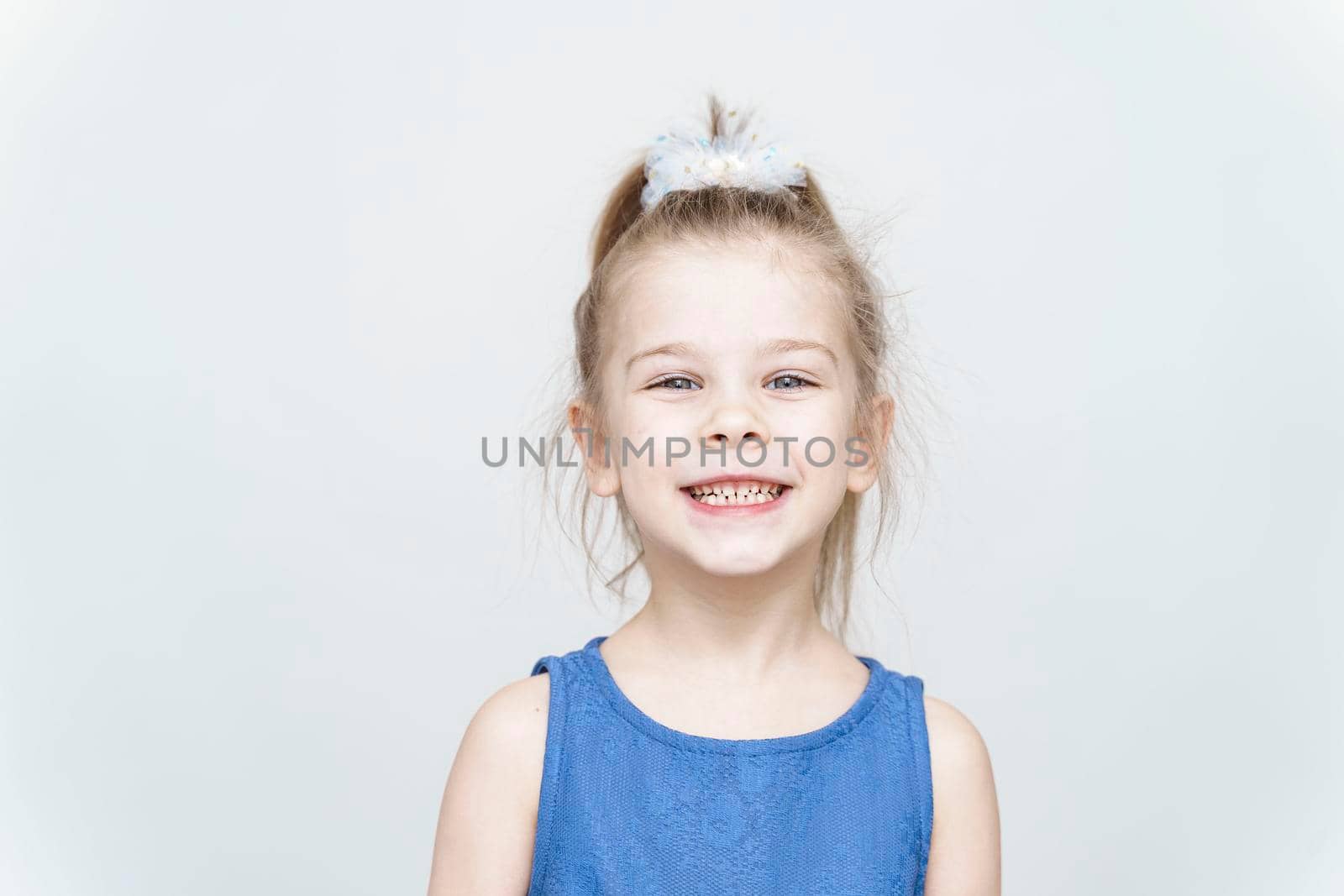 portrait of a cute 5-6 year old girl on a light background