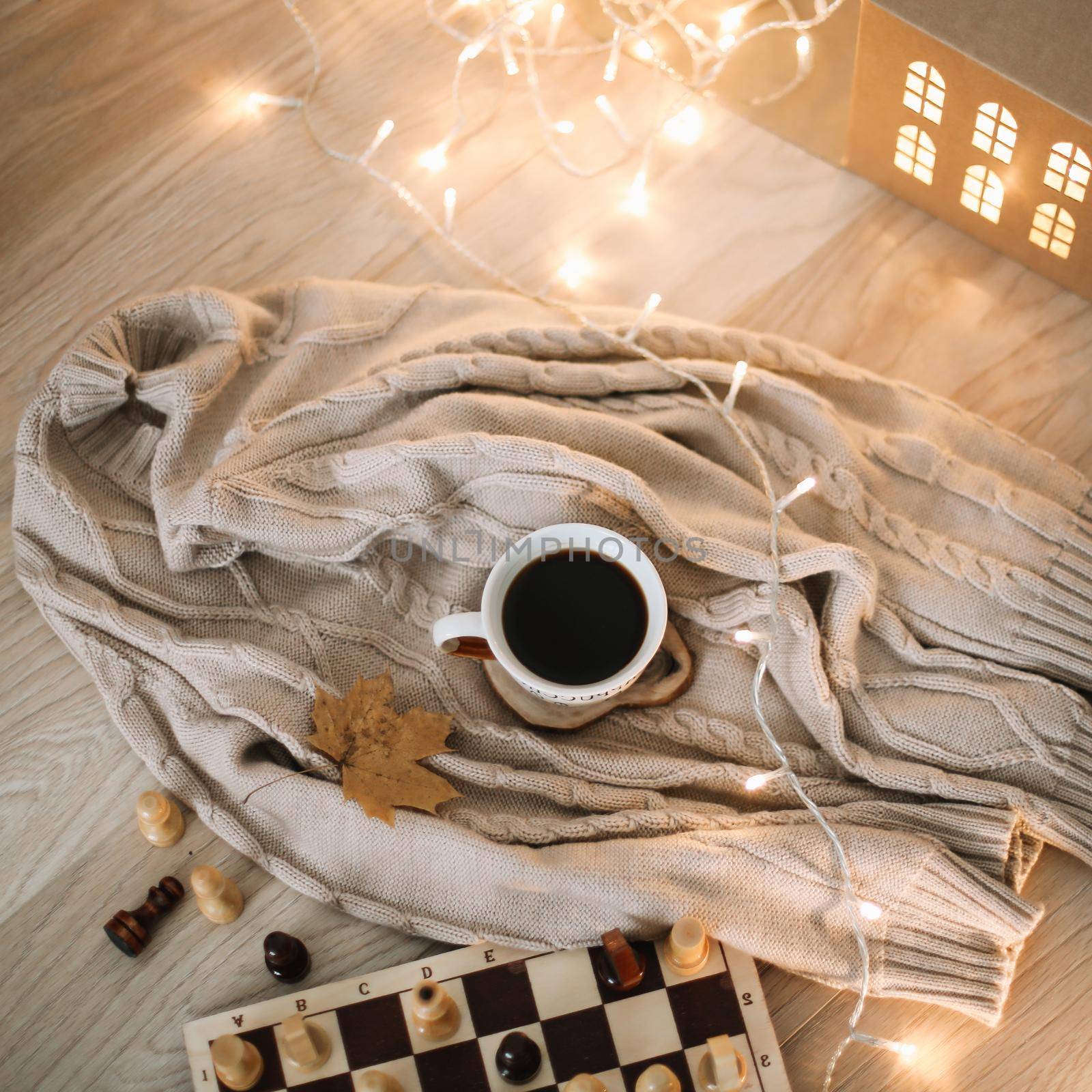 a cup of coffee on a knitted beige plaid