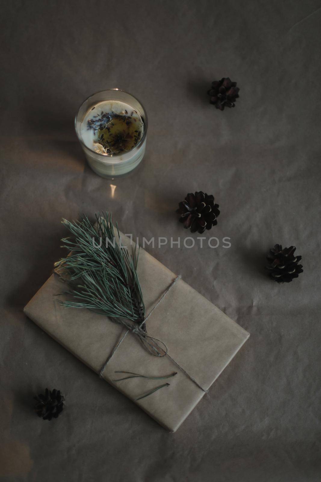 Christmas composition. Gift, fir tree branches, balls on craft paper background. Christmas, winter, new year concept. Flat lay, top view, copy space.