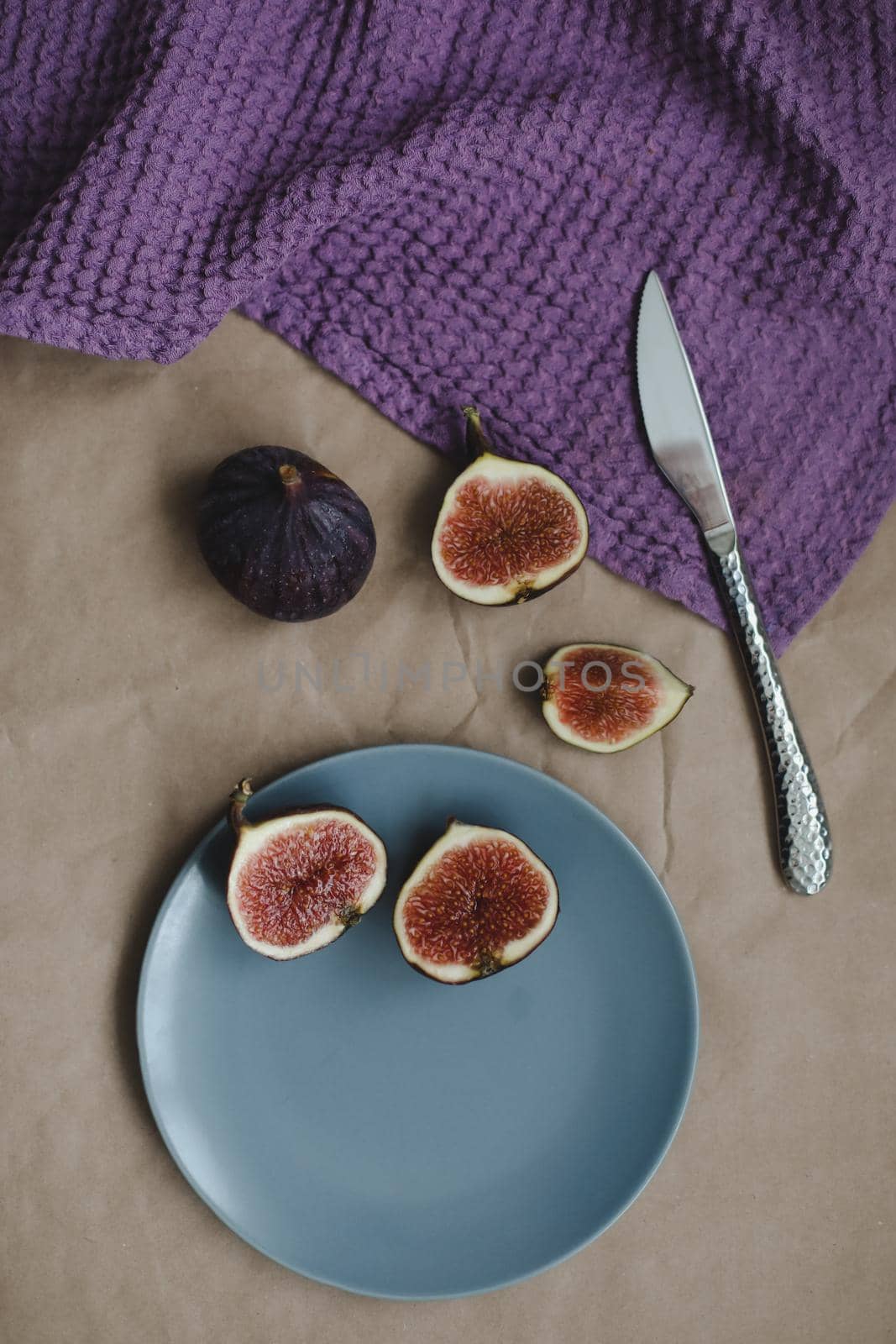 still life with ripe fresh figs and purple textiles on rustic background, flatlay, overhead view