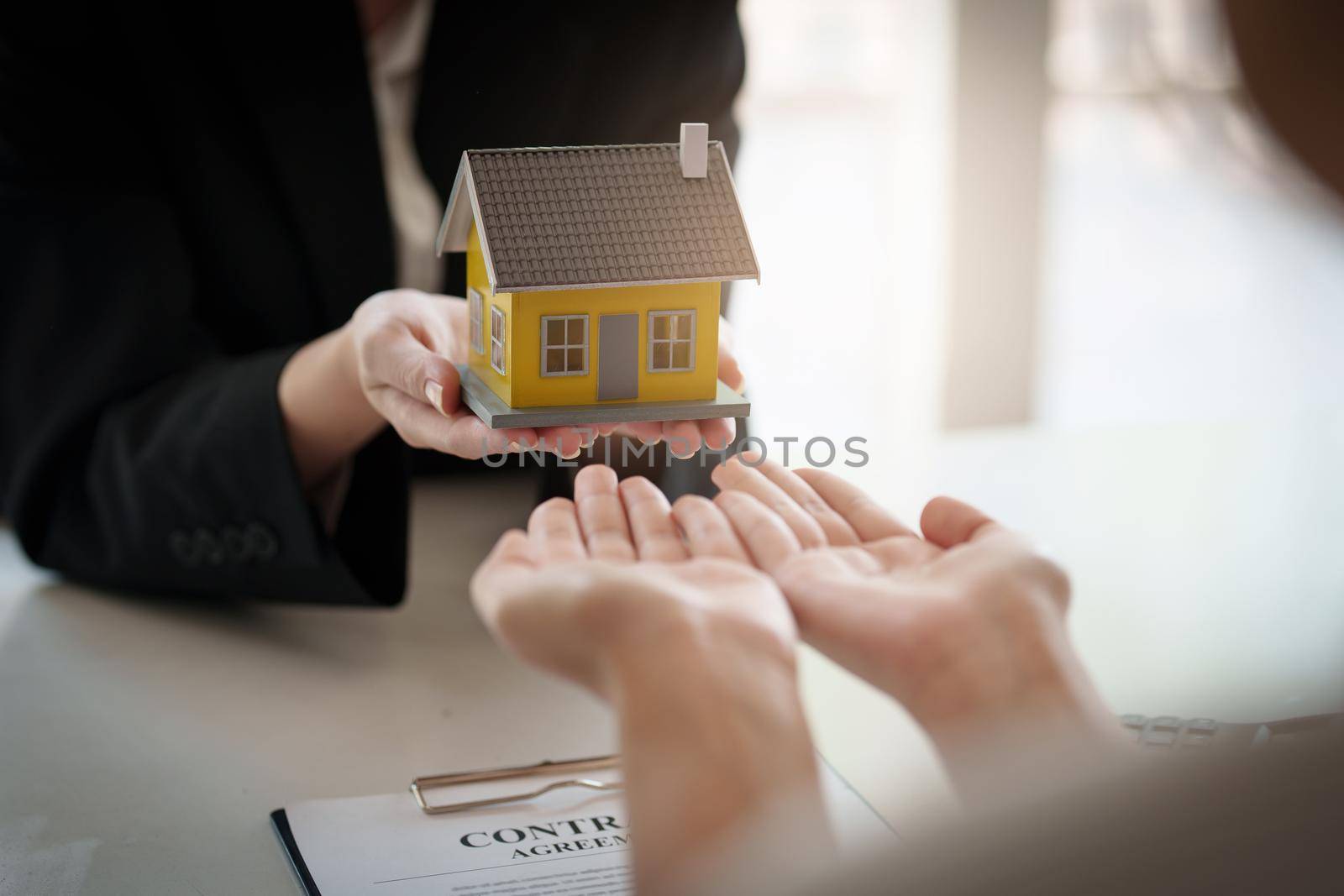 Close up Business woman or Real Estate agent explain signing agreement for buying house. Bank manager and real estate concept. by itchaznong