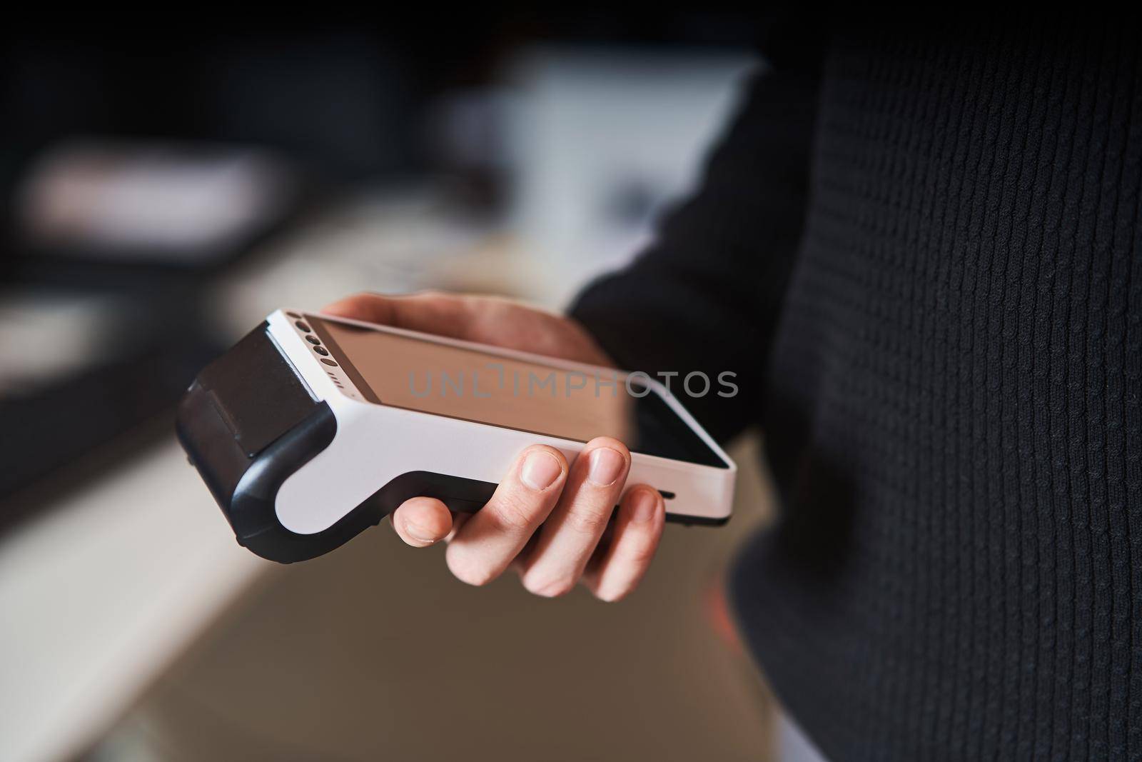 Bank terminal for contactless payment. Acquiring. Young man holds a terminal in his hands.