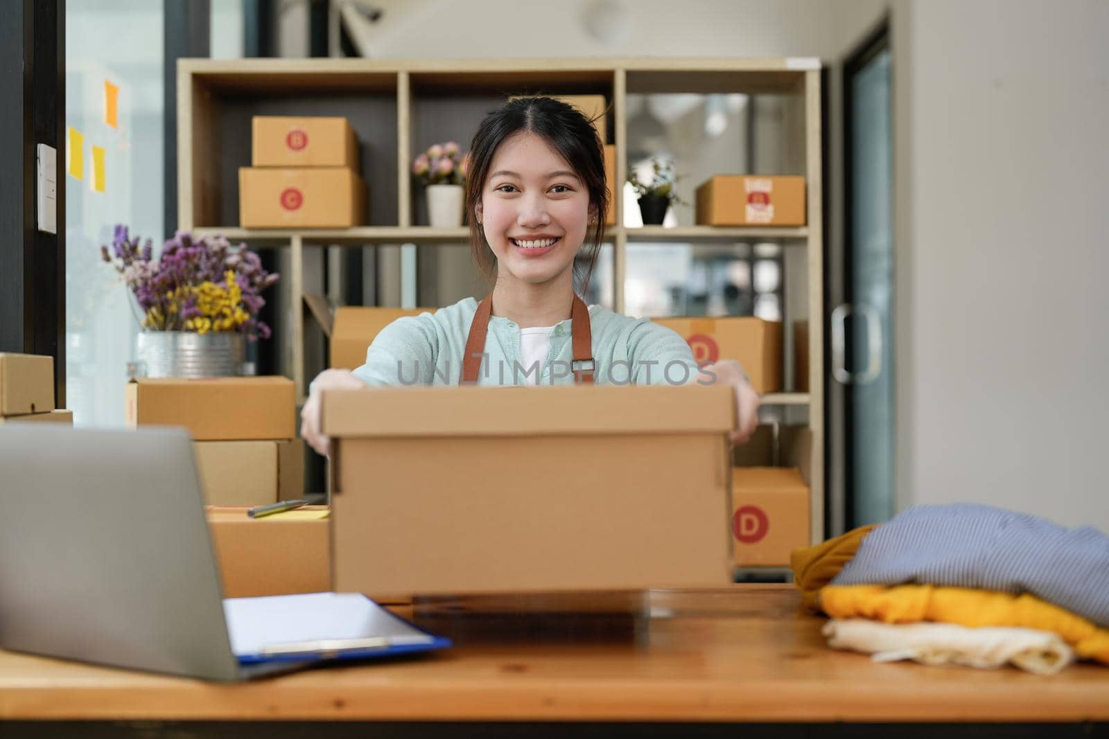 Startup small business entrepreneur SME, asian woman packing box. Portrait of young Asian small business owner in home office, online sell marketing delivery, SME e-commerce telemarketing concept.