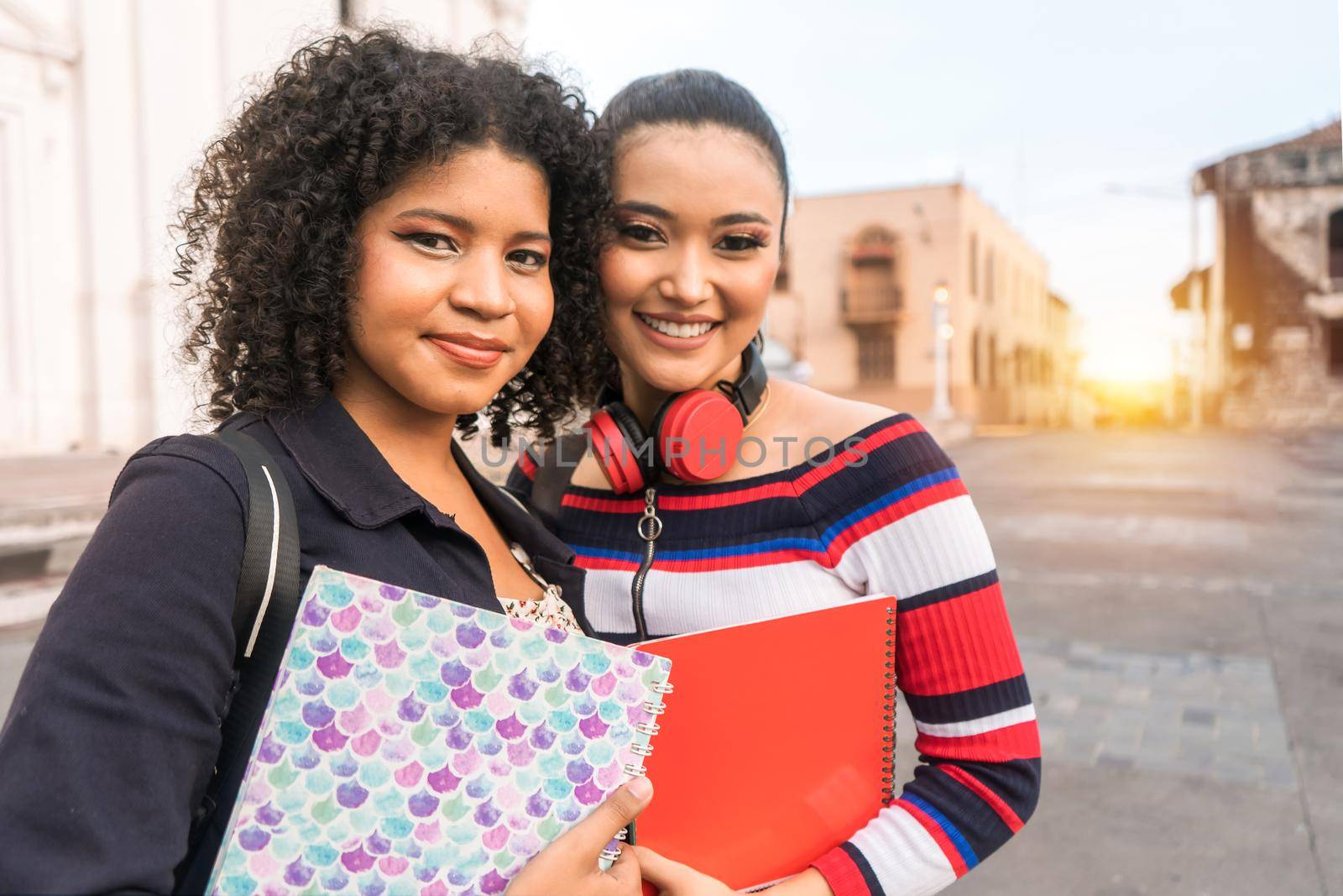 Two multiracial Latina students looking at the camera and smiling in the central park of Leon Nicaragua. Photo with copy space.