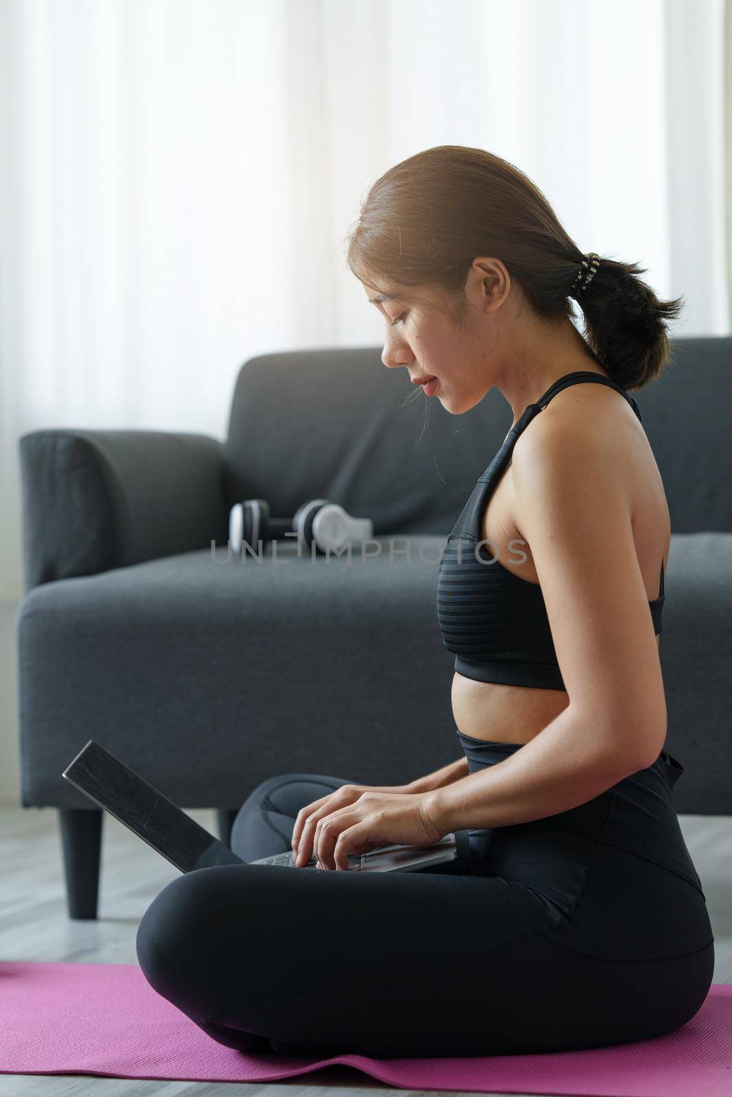 Young woman practicing yoga follow teacher in laptop online class at home. Calmness and relax concept