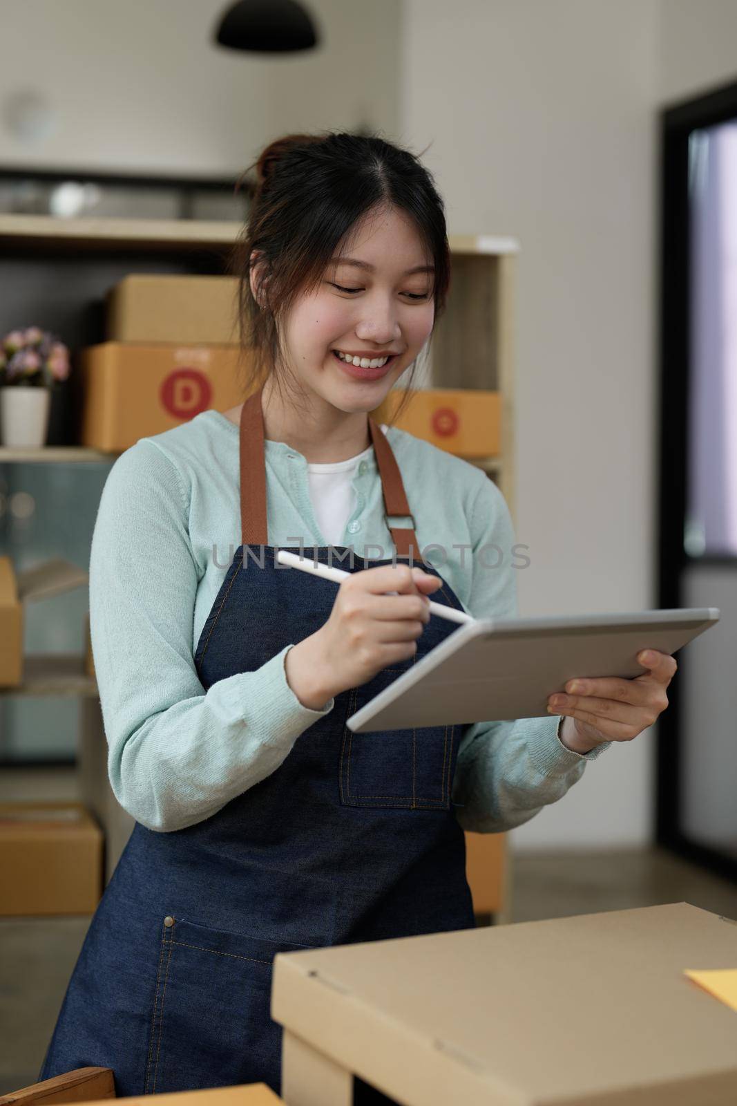 Startup small business entrepreneur SME, asian woman checking order. Portrait young Asian small business owner home office, online sell marketing delivery, SME e-commerce telemarketing concept by nateemee