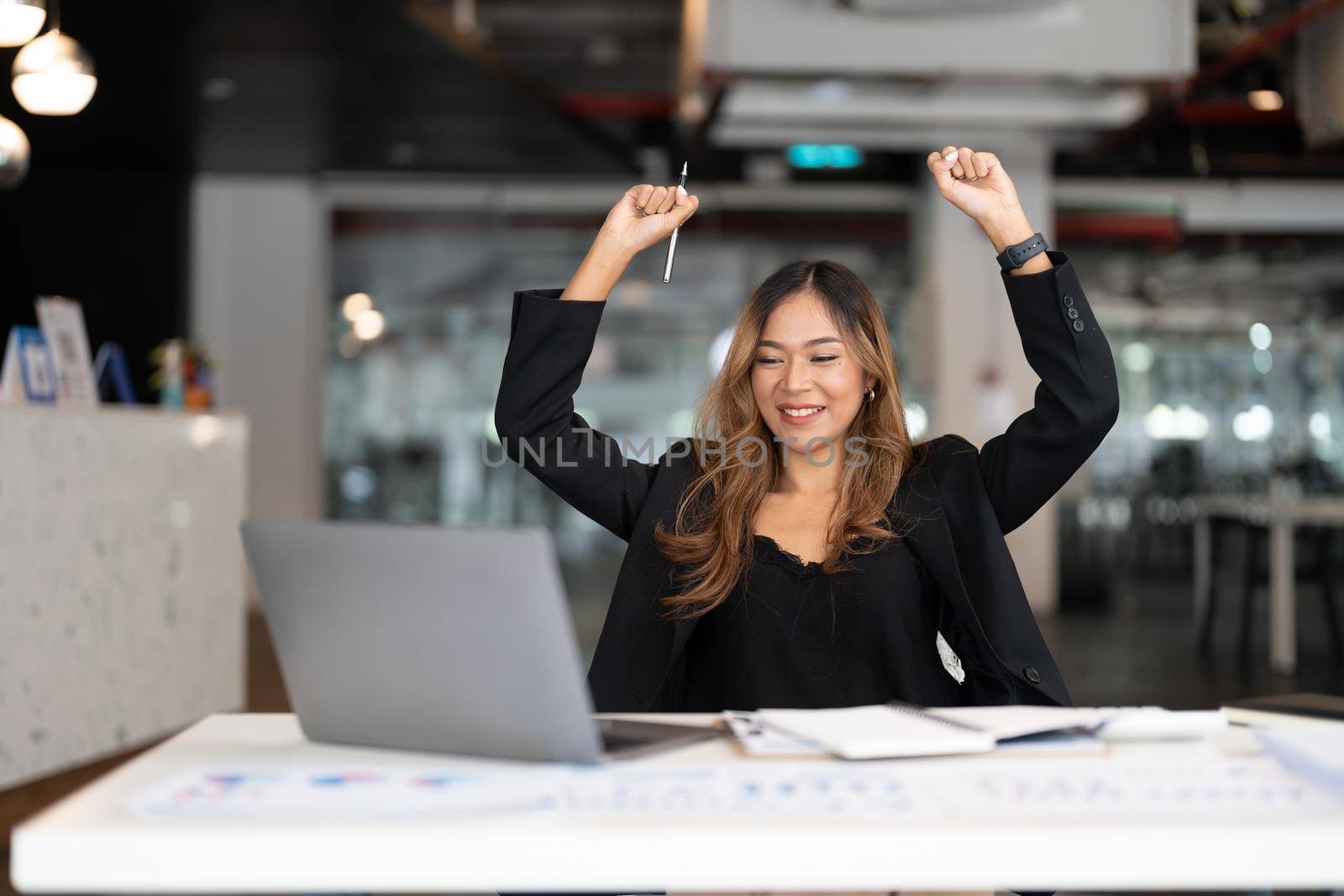 Portrait of happy young business asian woman celebrating success with arms up. positive expression, sucess in business concept.