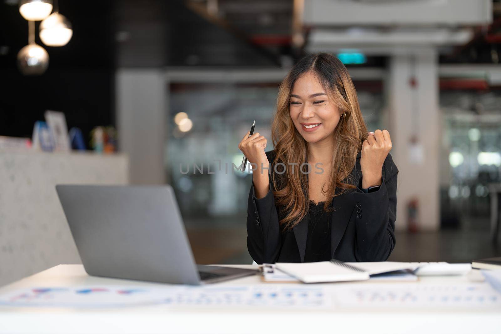 Portrait of happy young business asian woman celebrating success with arms up. positive expression, sucess in business concept.
