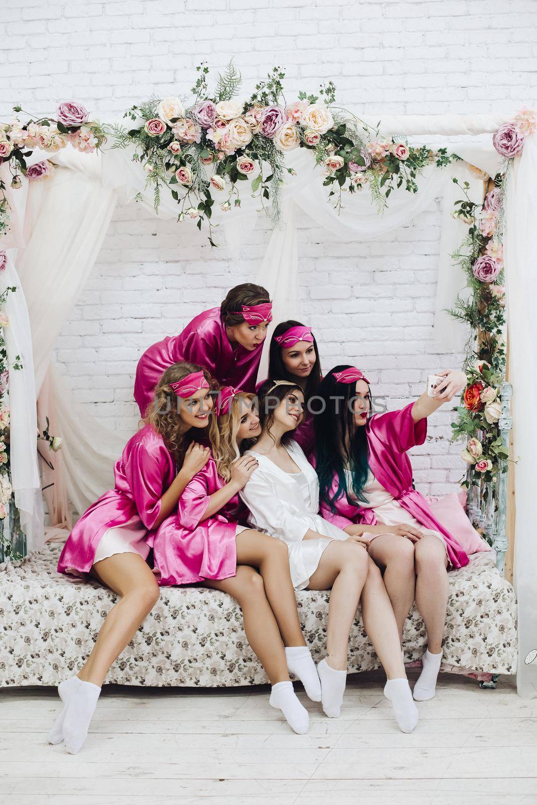 Pretty bridesmaids with bride taking selfie at hen party. by StudioLucky