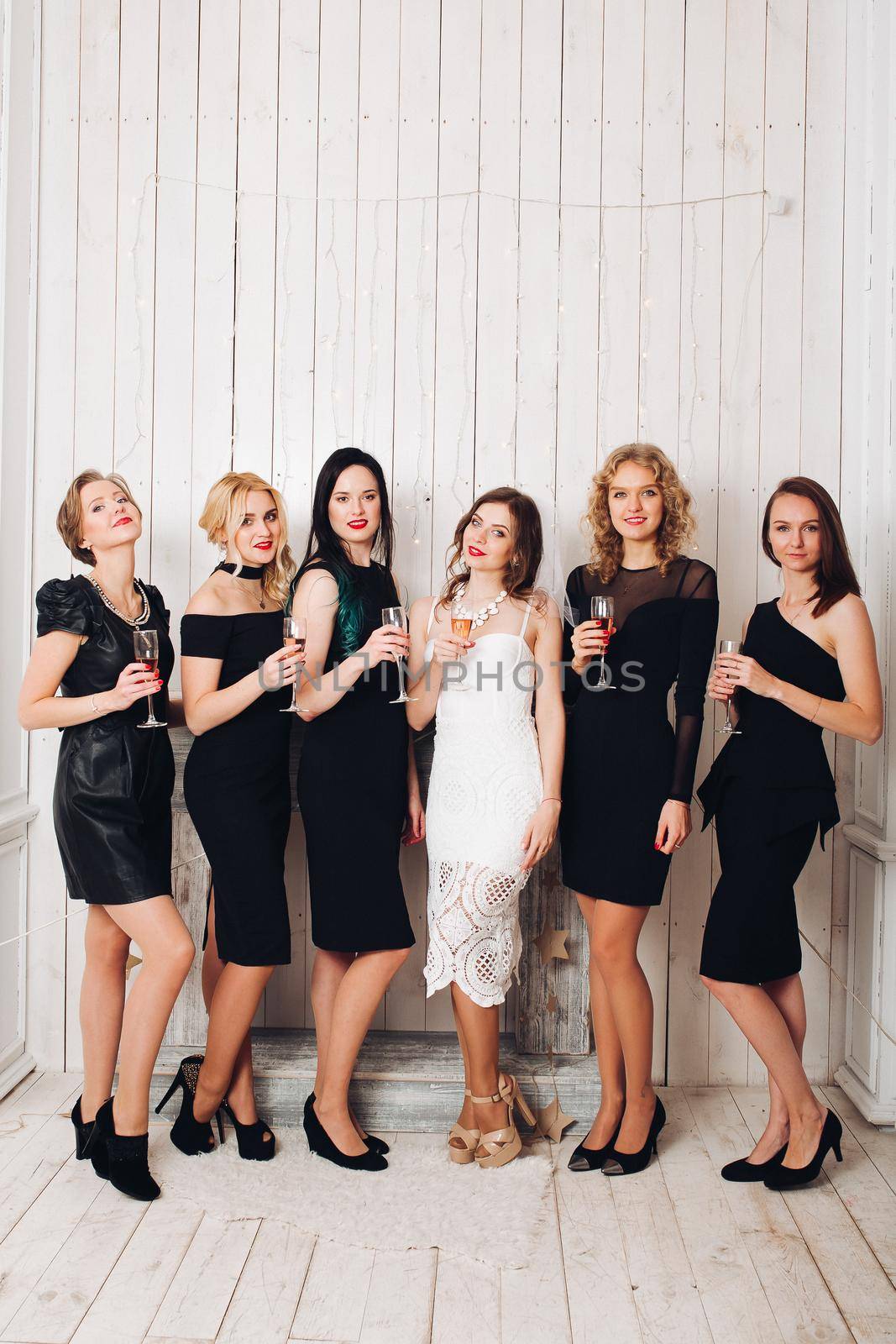 Beautiful girls in black dresses toasting with bride. by StudioLucky